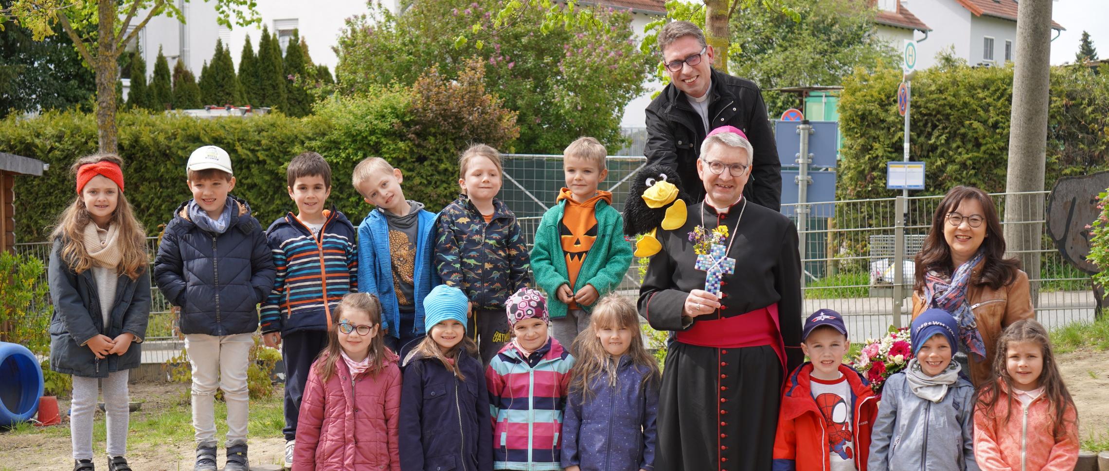 Kita-Kinder mit Bischof Kohlgraf und dem Raben Rudi
