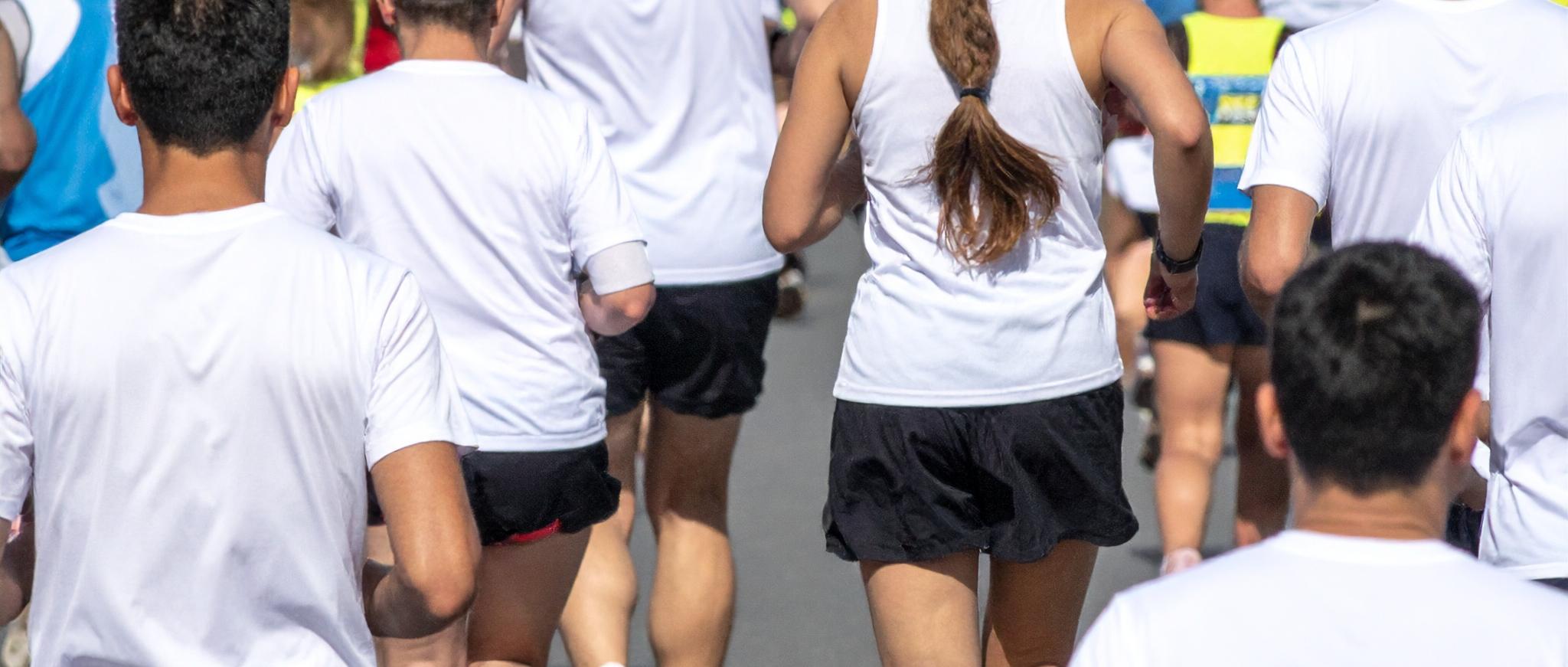Eine große Gruppe von Menschen läuft bei einem Sportevent durch die Stadt.