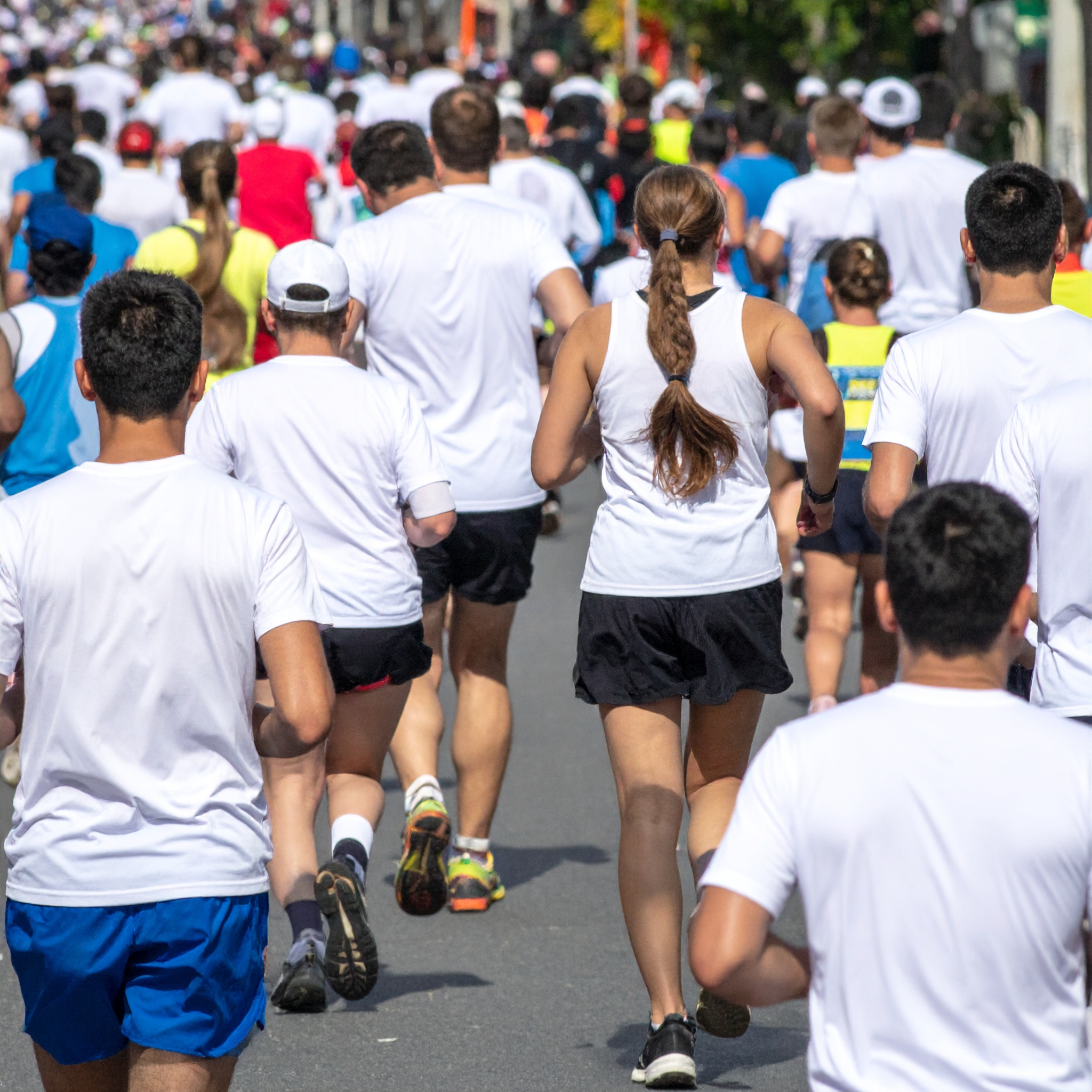Eine große Gruppe von Menschen läuft bei einem Sportevent durch die Stadt.
