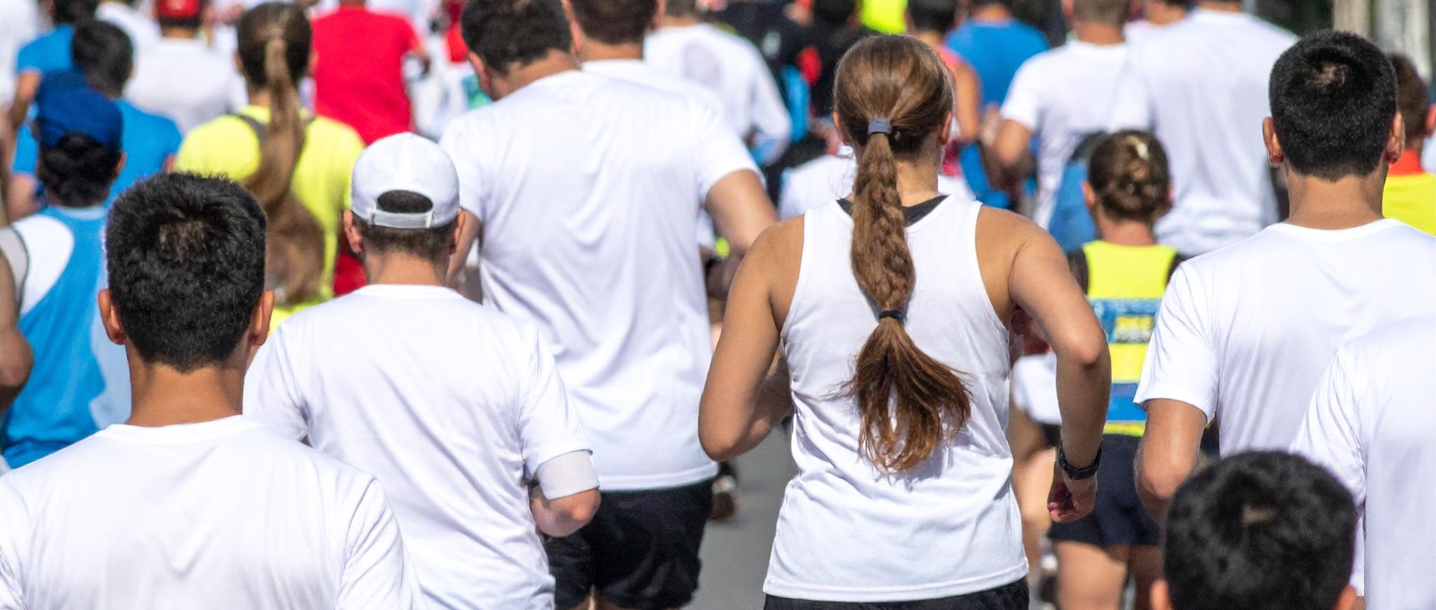 Eine große Gruppe von Menschen läuft bei einem Sportevent durch die Stadt.