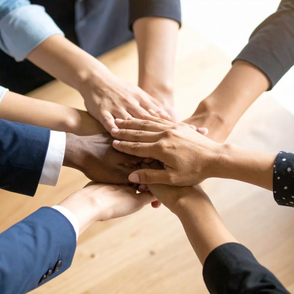 Mehrere Hände liegen übereinander und bilden einen Stapel.