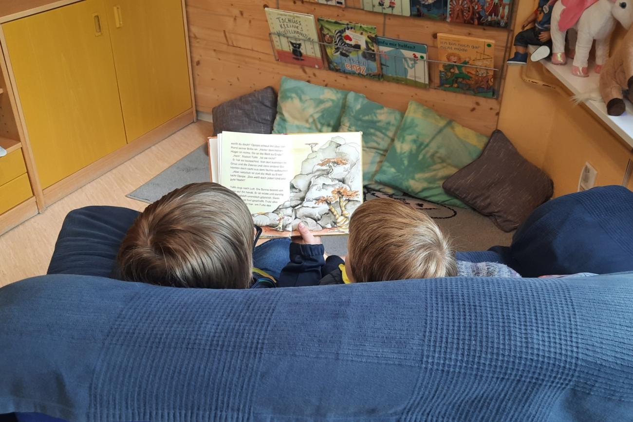 zwei lesende Kinder auf Couch