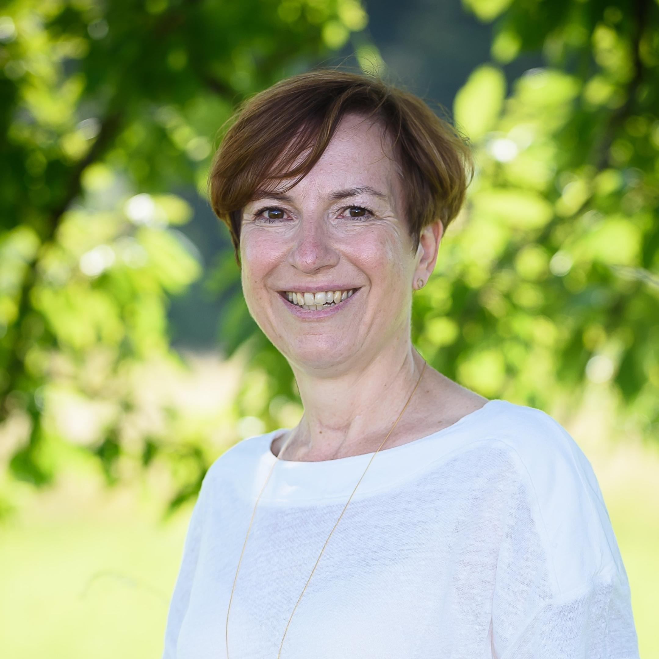 Frau, steht draußen, Bäume, Gras, lächelt
