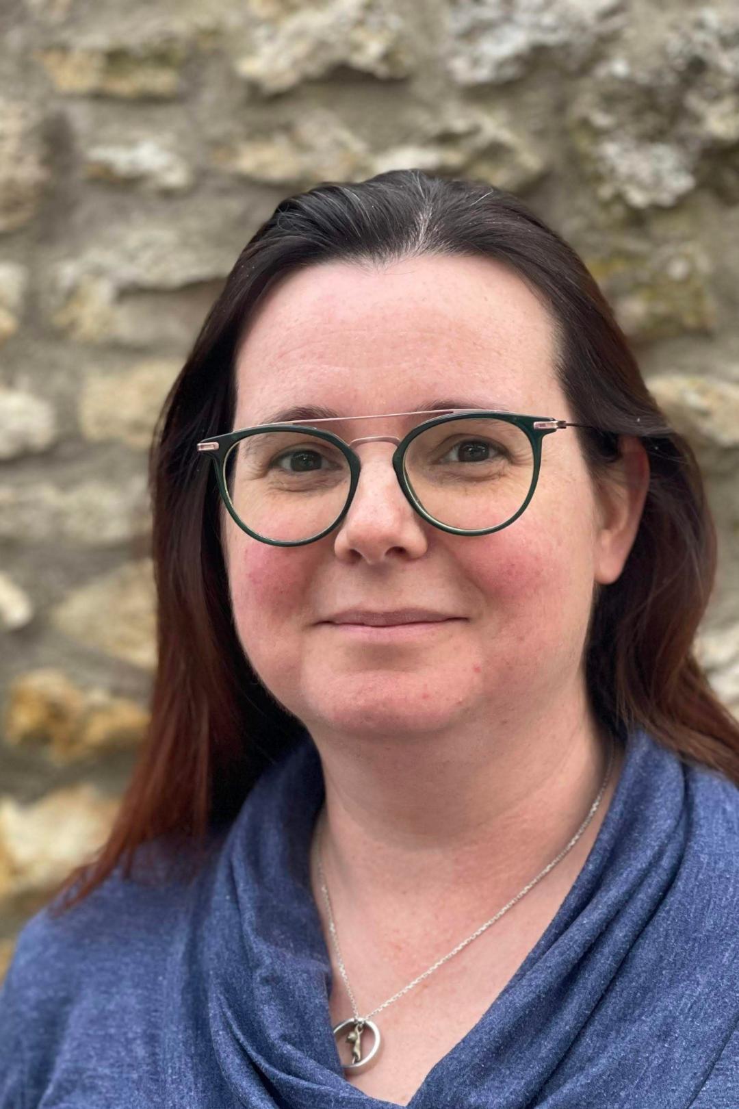 Eine Frau mit langen, braunen Haaren und Brille