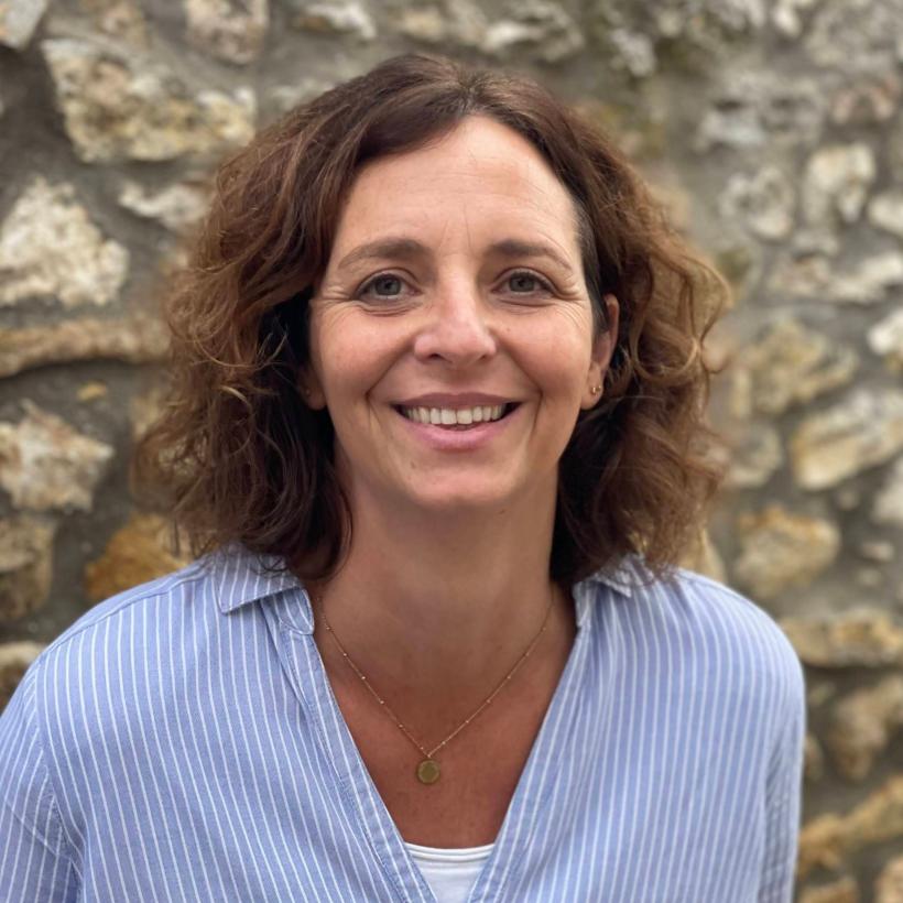 Eine Frau mit schulterlangen, braunen Locken