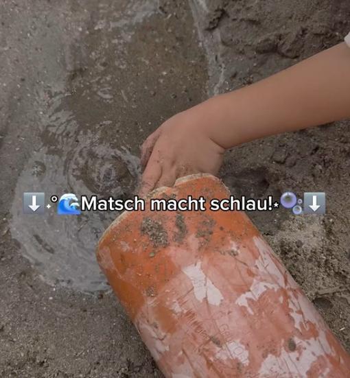 Kinder spielen mit Wasser im Sand