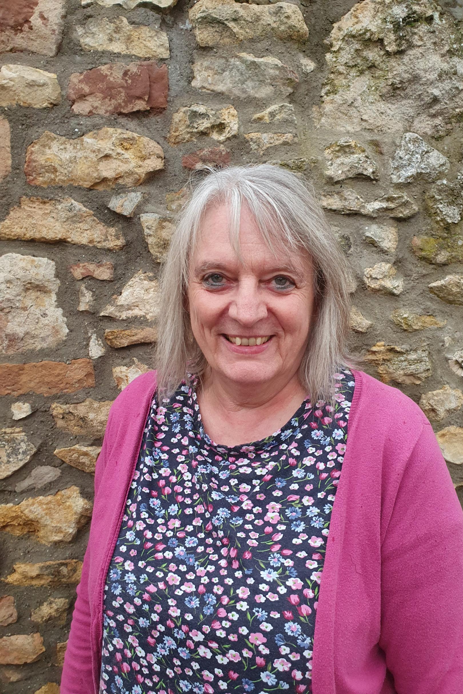 Eine Frau mit schulterlangen, grauen Haaren.